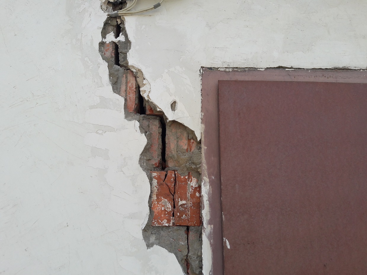 Трещины в стенах дома. Трещина в дверном проеме. Трещина в здании. Трещина в кирпичной стене. Трещины на штукатурке.
